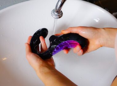 person holding black and purple cordless game controller