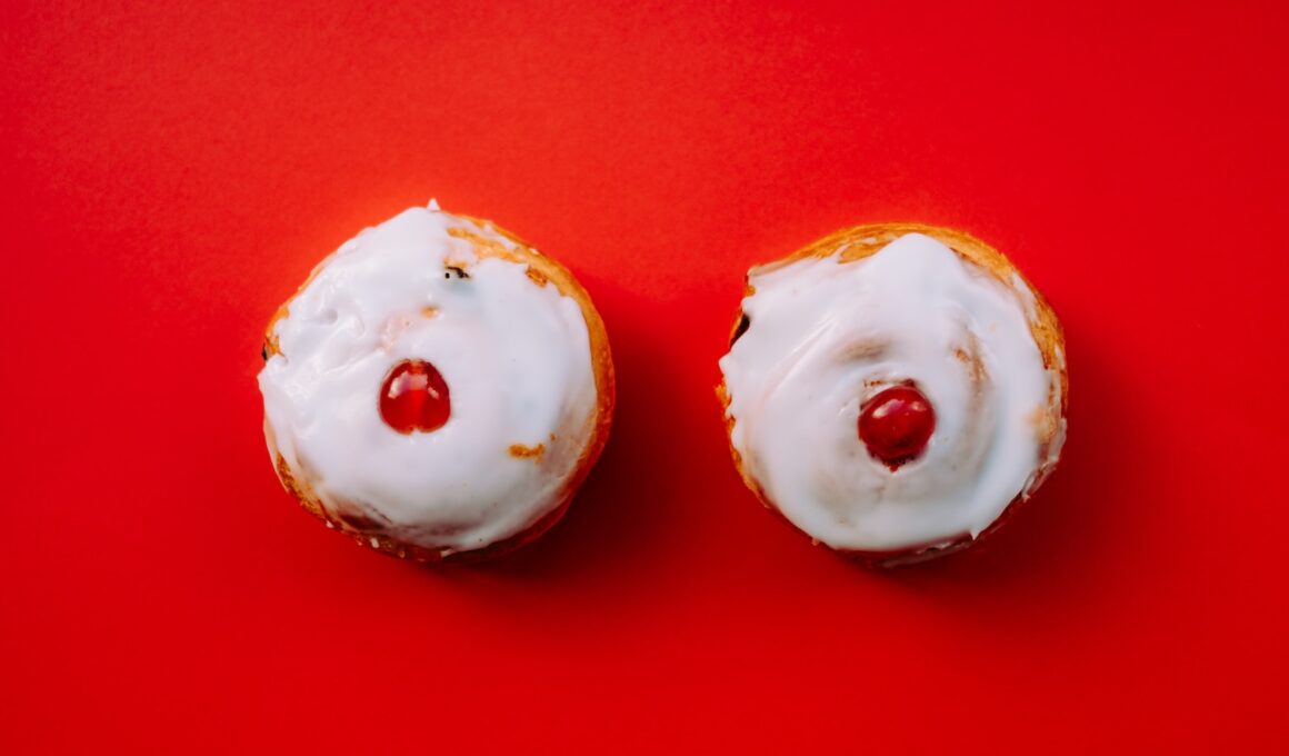 two white frosted cupcakes with cherry toppings
