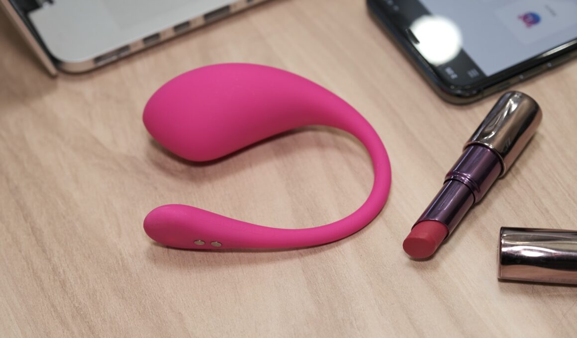 a table with a cell phone, lipstick, and a laptop