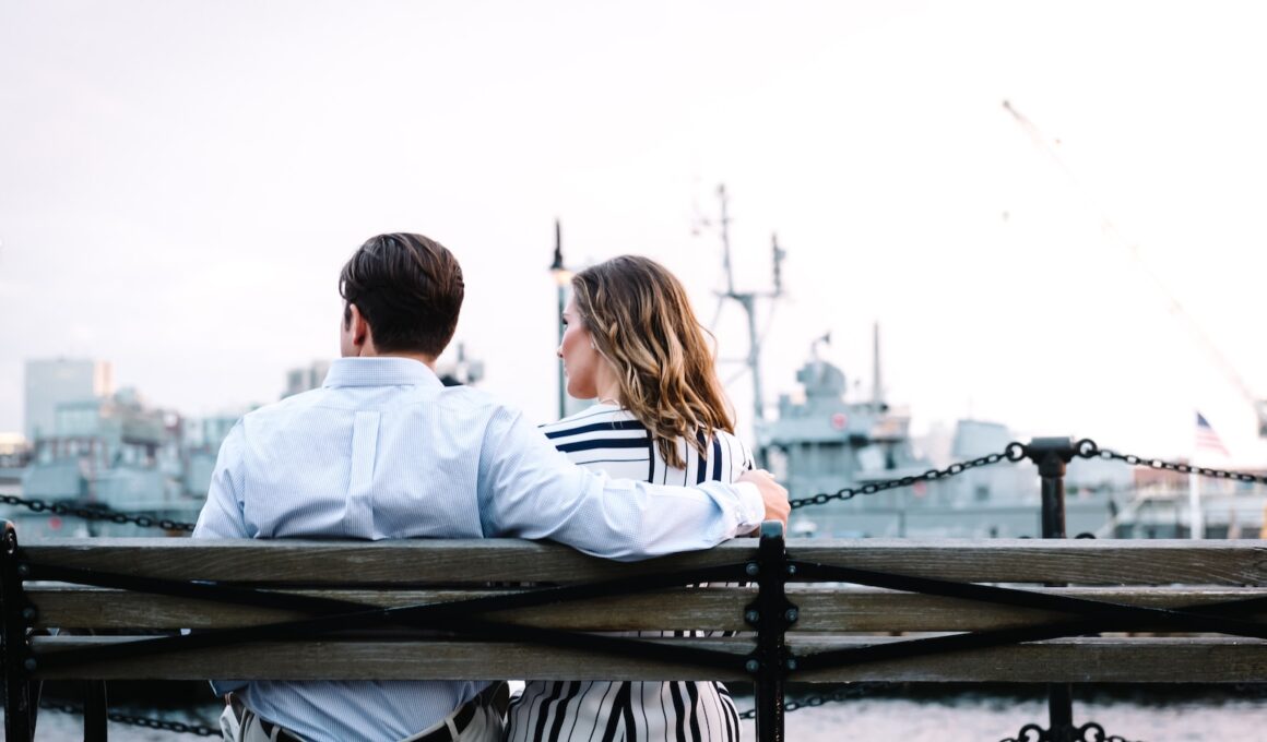 couple sitting on bench near body of water